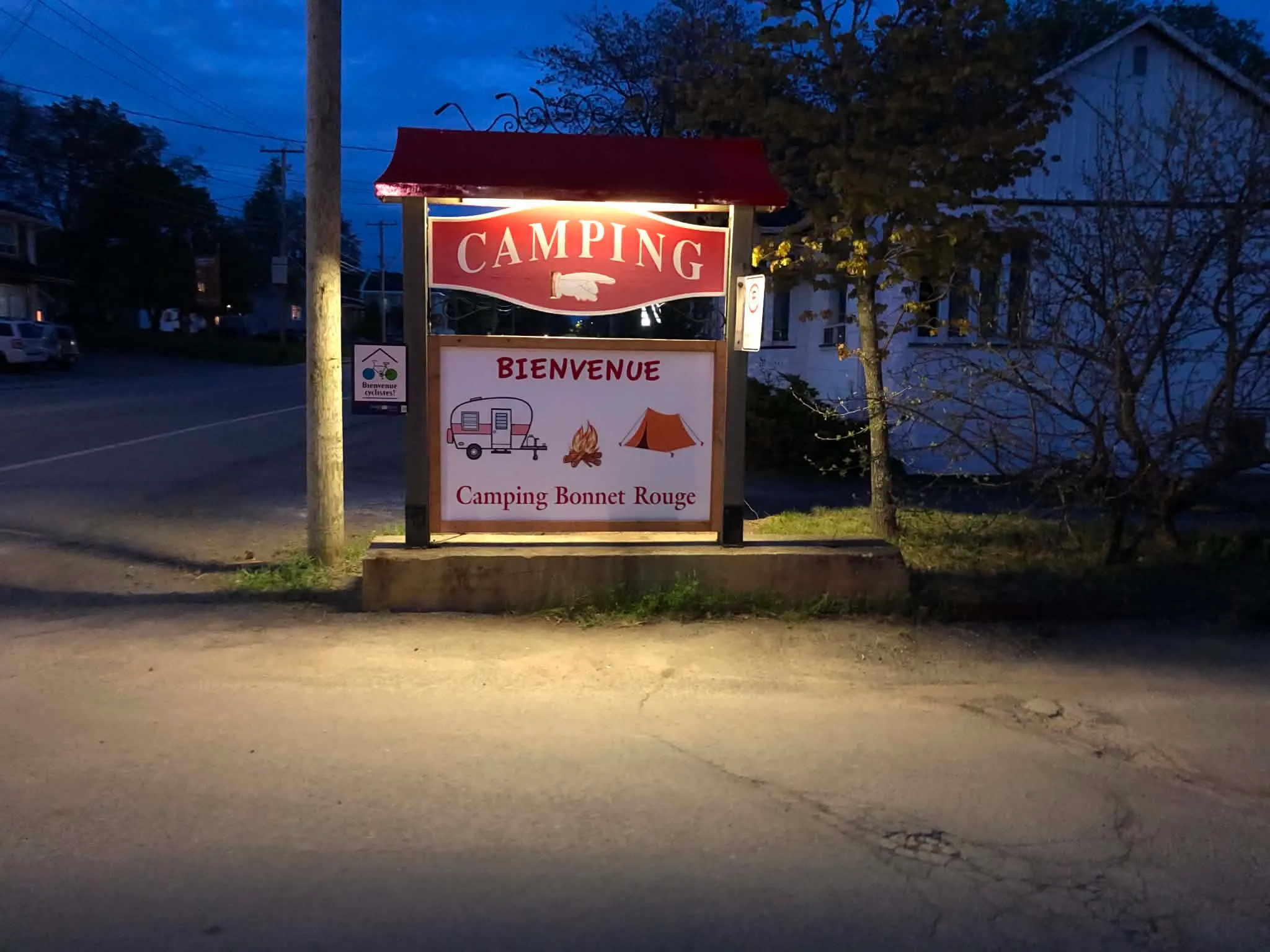 Panneau d'entrée du Camping Bonnet Rouge, illuminé en soirée